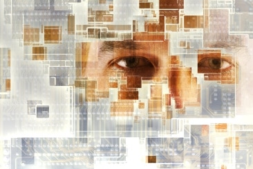 A man looks through a circuit board. (Thinkstock: Chad Baker/Ryan McVay)