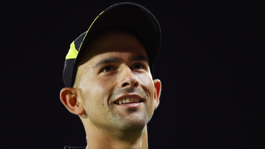 Ashton Agar smiles while wearing an Australian cricket hat