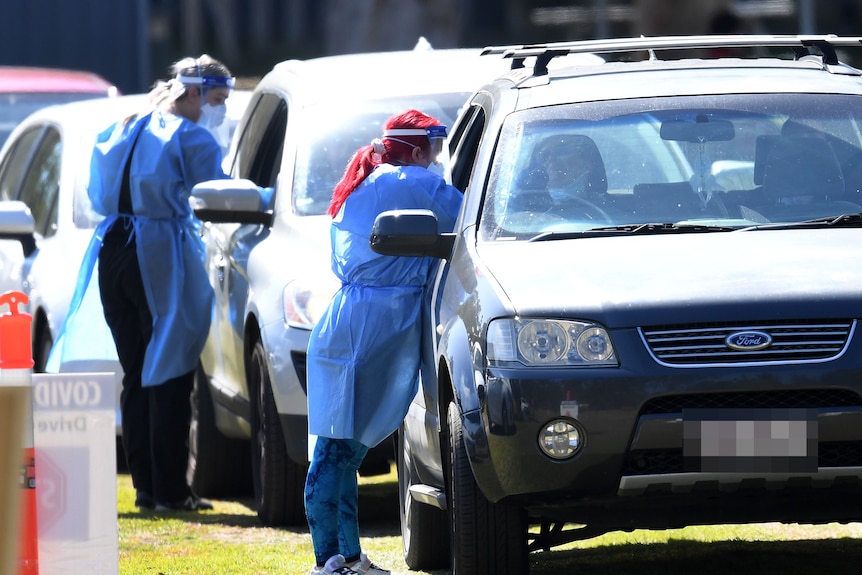 Health workers swab members of the public in their cars