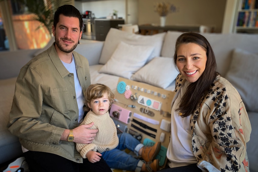 man, son and woman sitting in living room