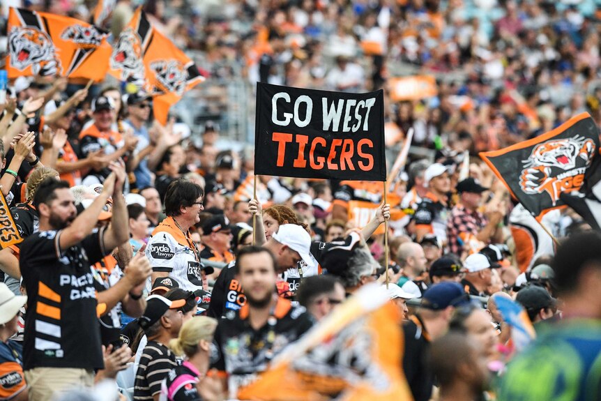 Wests Tigers fans hold a banner