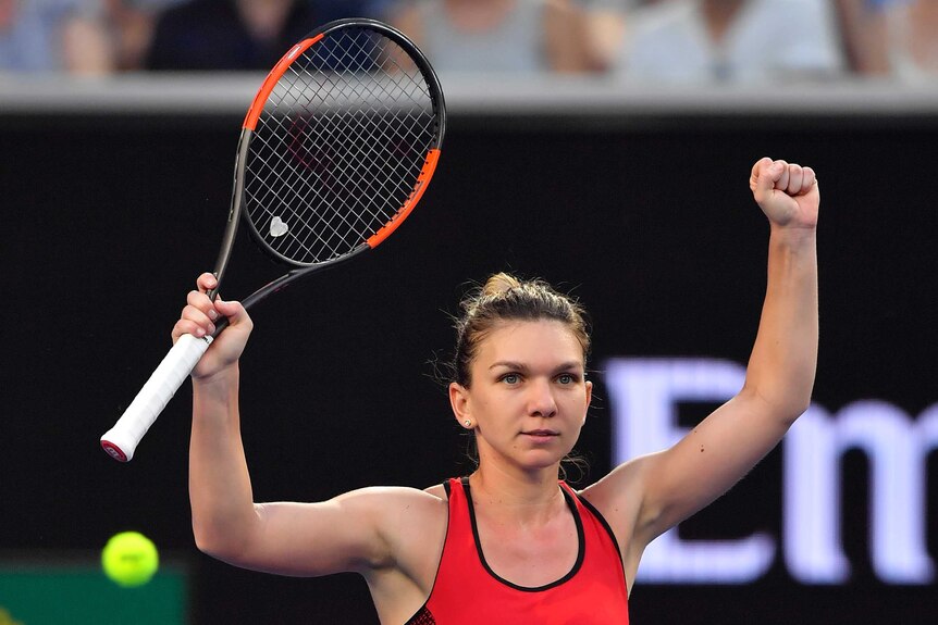 Simona Halep raises both her arms as she celebrates beating Eugenie Bouchard in the Australian Open second round.