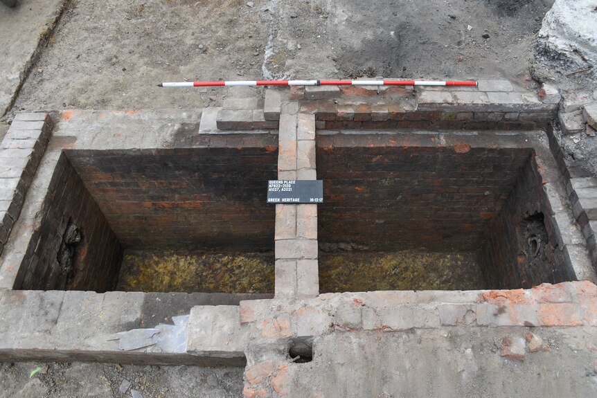 A hole in the ground lined with bricks.
