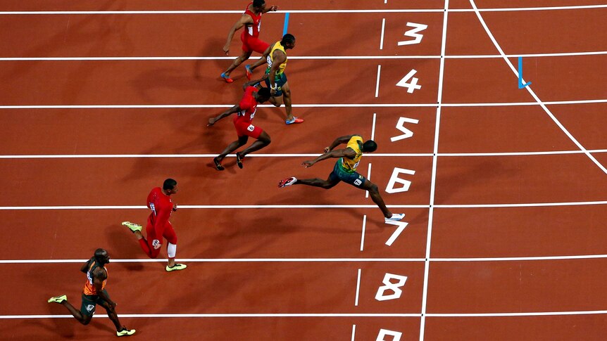 Jamaica's Usain Bolt (R) crosses the finish line to win the men's 100m final.
