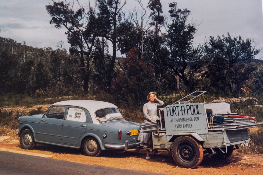 An older-style photo of a woman with a car towing a trailer with the sign "port-a-pool".