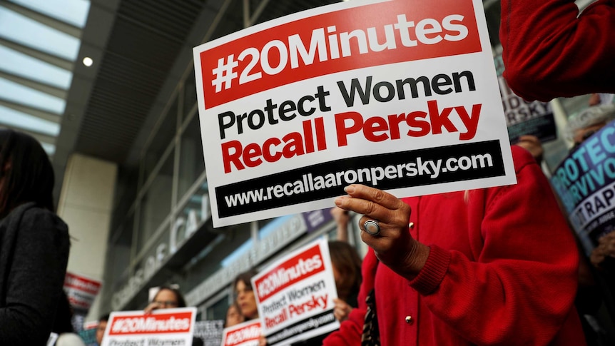 Activists hold signs calling for the removal of Judge Aaron Persky