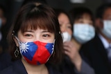 A woman with long hair wears a face mask with the flag of Taiwan on it