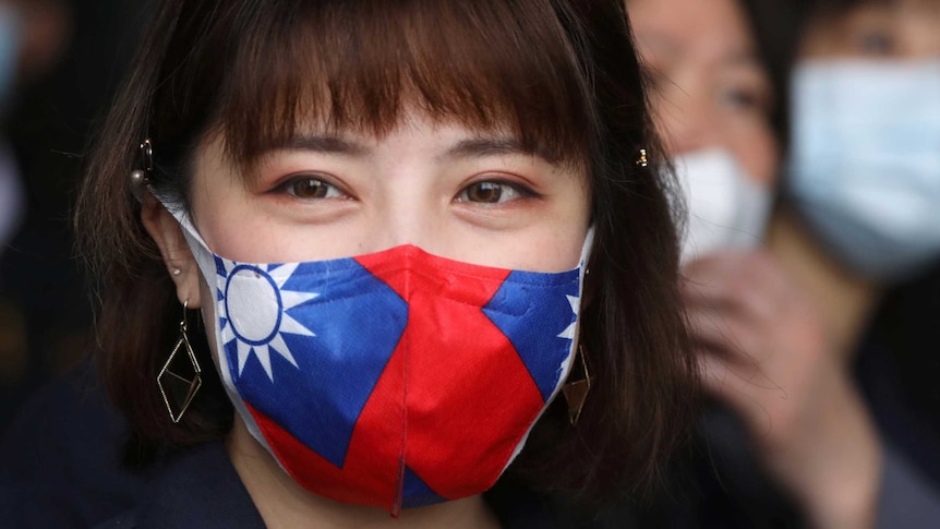 A woman with long hair wears a face mask with the flag of Taiwan on it