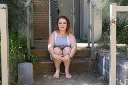 Jade Lomas sitting in front of her rental property in Bankstown