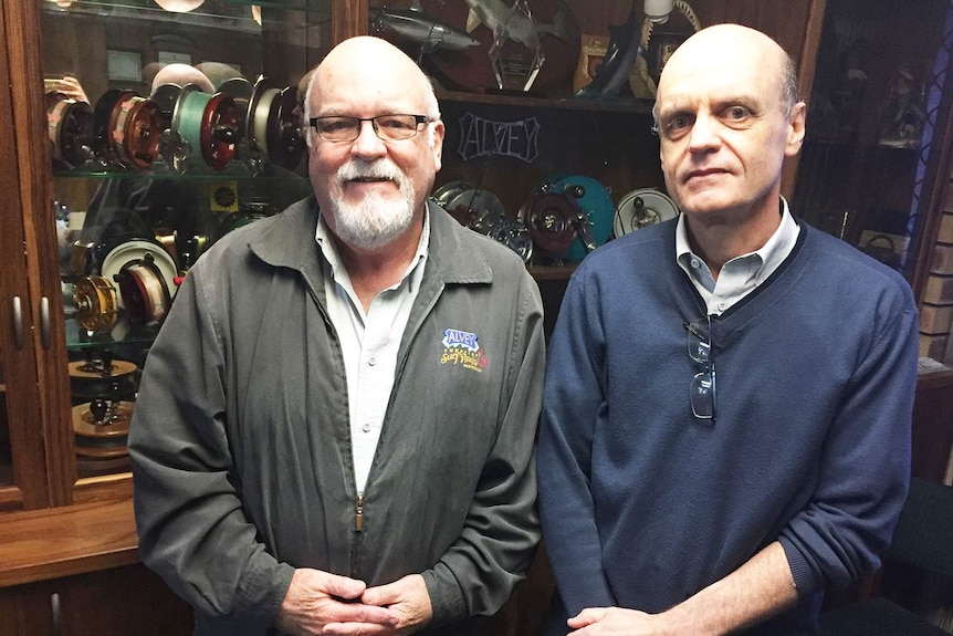 Bruce and Glenn Alvey stand together at their fishing reel factory in Ipswich.