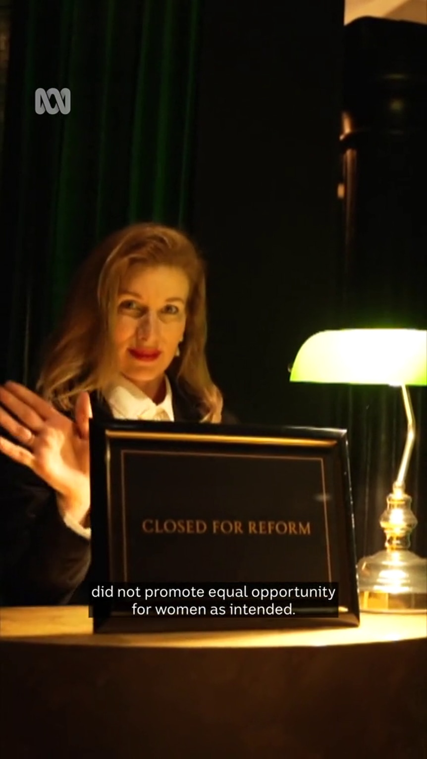 Neatly dressed middle-aged white woman sits near lamp with sign that reads "closed for reform"