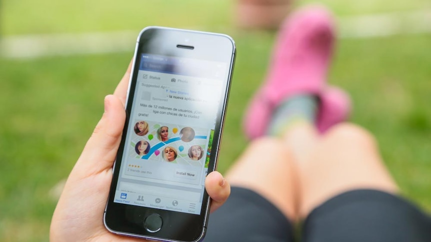 A person holding a mobile phone while lying down outdoors