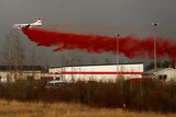 A plane flies low to dump fire retardant on wildfires near Fort McMurray.
