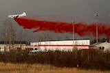 A plane flies low to dump fire retardant on wildfires near Fort McMurray.