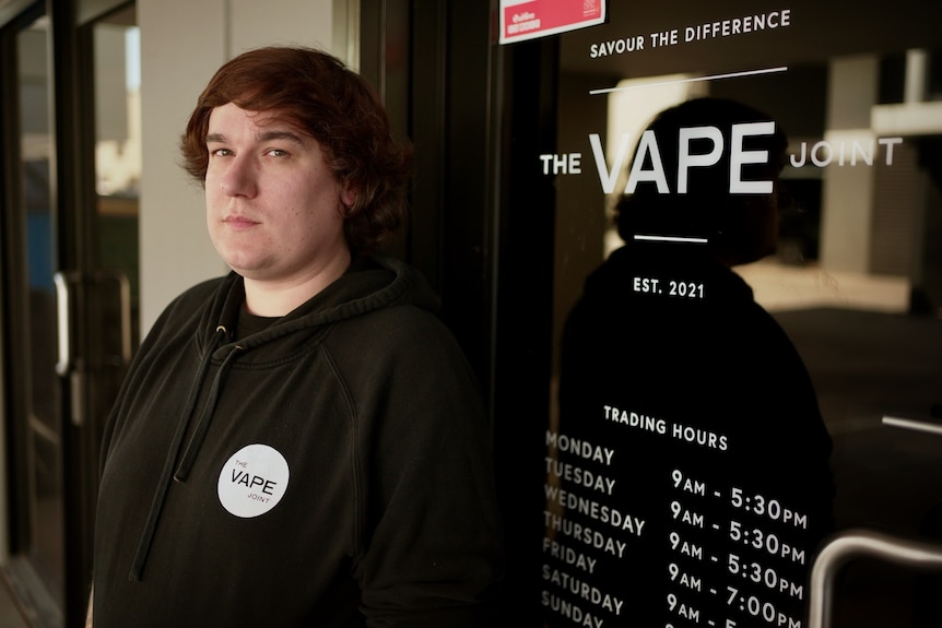 Sean White wears a black hoodie with a logo of the vape shop he used to work at.