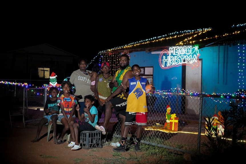 A family stands outside their decorated home