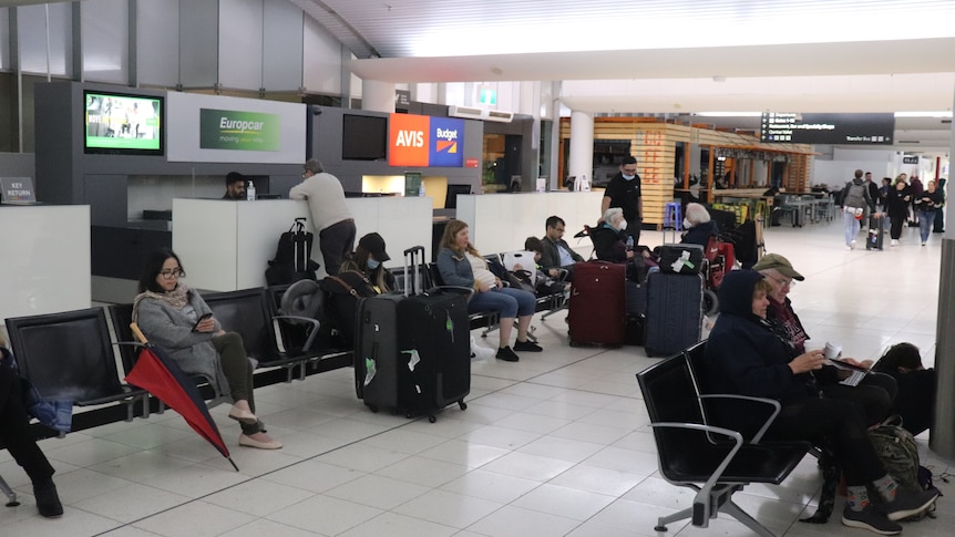 A wide shot of passengers sitting inside a terminal at Perth Airport.