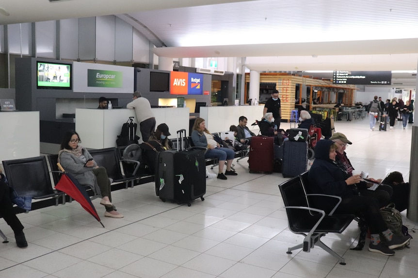 A wide shot of passengers sitting inside a terminal at Perth Airport.