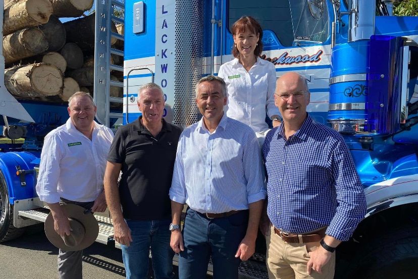 Tim Bull, Peter Walsh, Darren Chester, Danny O'Brien and Melina Bath at the heyfield timber festival in front of logging truck.