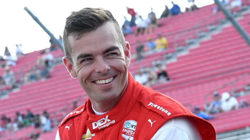 Scott mcLaughlin smiles in front of a grandstand