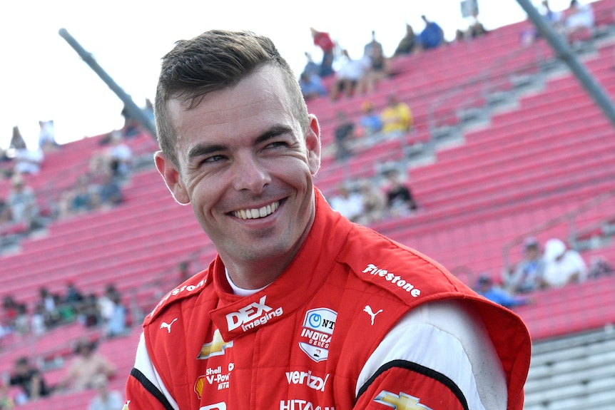 Scott mcLaughlin smiles in front of a grandstand