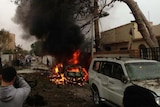 A car burns after a bomb explosion outside the French embassy in Tripoli