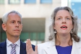 Andrew Giles stands next to Clare O'Neil at a press conference 