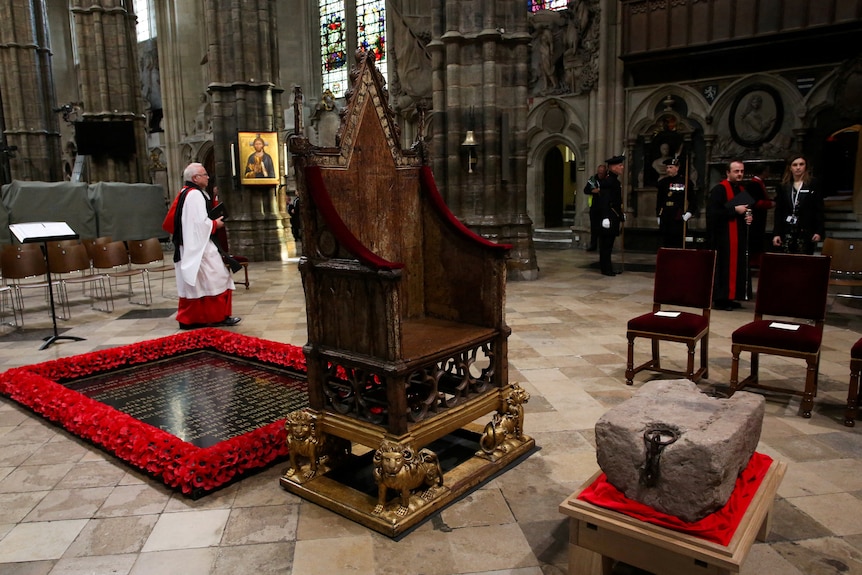 The coronation chair as it sits adjacent to the Stone of Scone inside Westminster Abbey.
