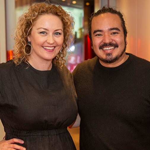 Zan Rowe and celebrity chef Adam Liaw both wearing black standing in the hallway of triple j