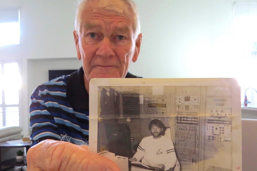 Kevin Gallegos holds a photo of himself from the 1960s.