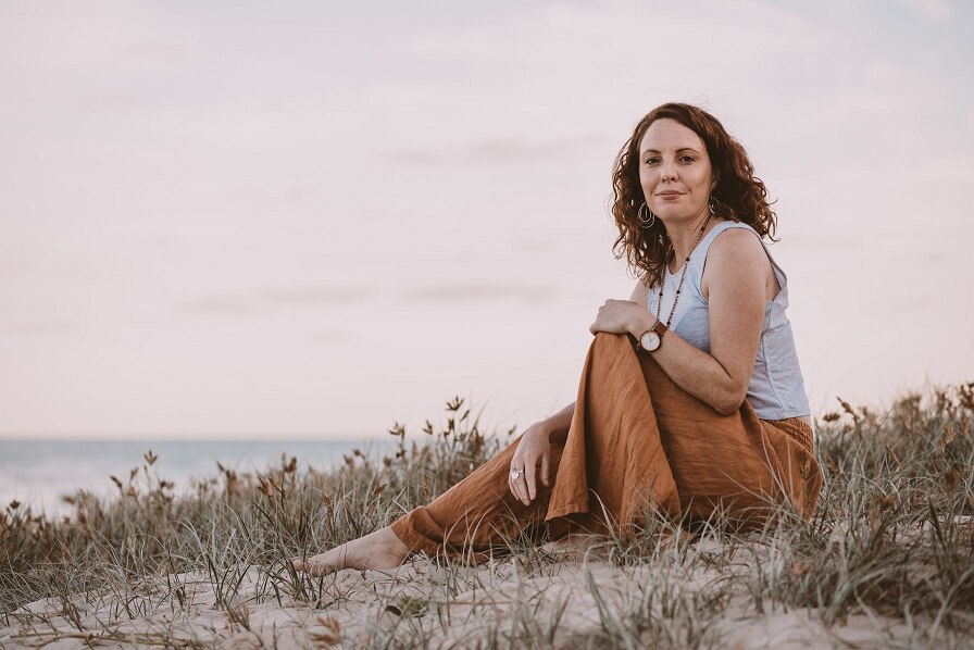 Lea Clothier finance expert sitting at the beach