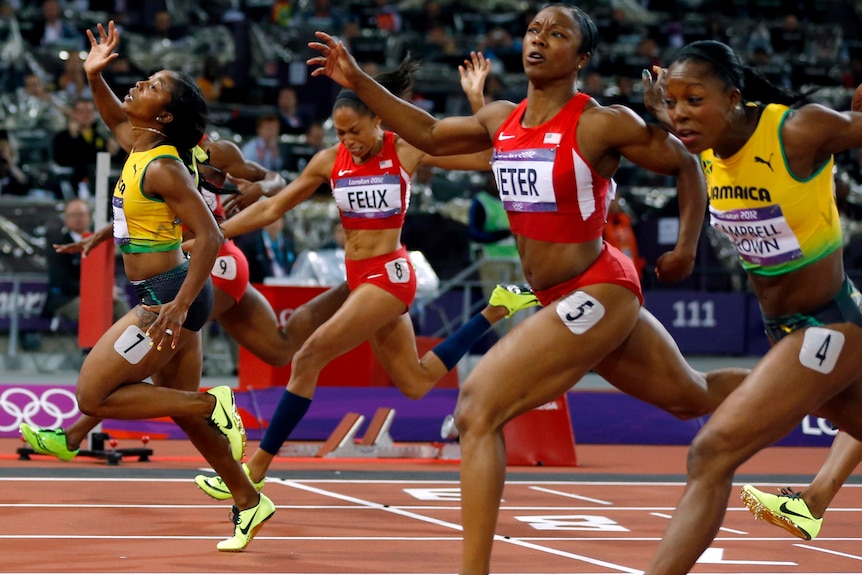 Jamaica's Shelly-Ann Fraser-Pryce (L) crosses the finish line to win the women's 100m final.