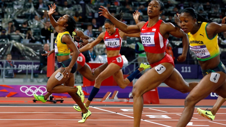 Jamaica's Shelly-Ann Fraser-Pryce (L) crosses the finish line to win the women's 100m final.