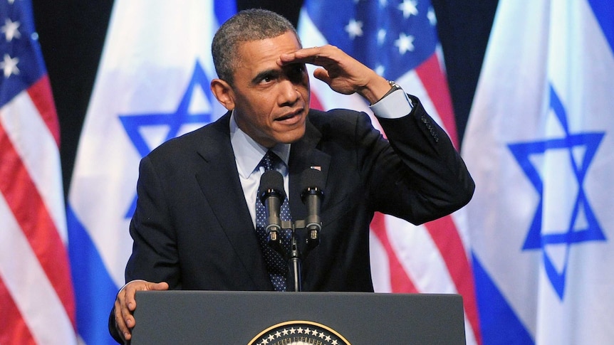 US President Barack Obama shields his eyes as he looks up at a person who shouted out during his speech to the Israeli people at the Jerusalem International Convention Center in Jerusalem on March 21 2013