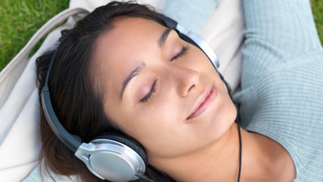 Woman listening to music through headphones