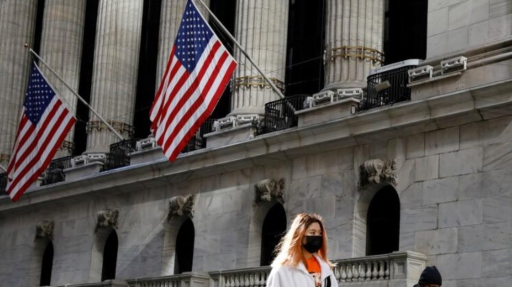 A woman wears a mask near the New York Stock Exchange (NYSE) in the Financial District in New York.