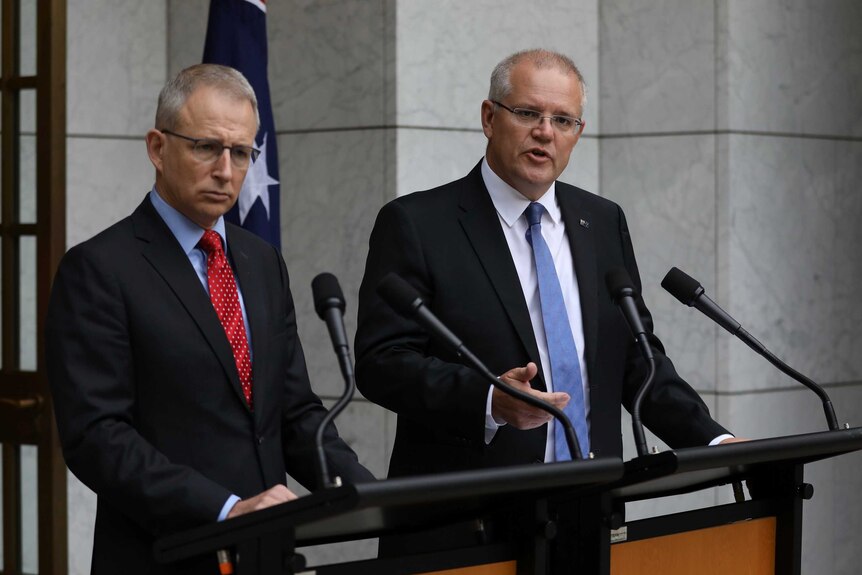 Paul Fletcher and Scott Morrison stand at podiums responding to questions in the Prime Minister's courtyard