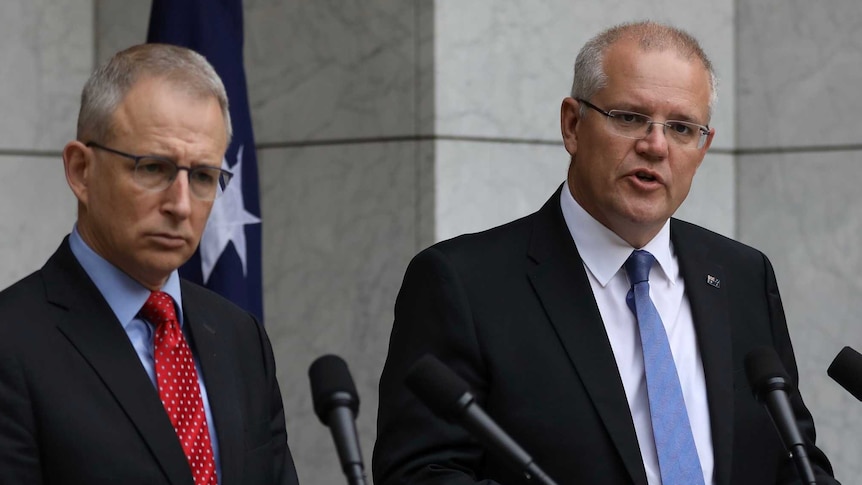 Paul Fletcher and Scott Morrison stand at podiums responding to questions in the Prime Minister's courtyard