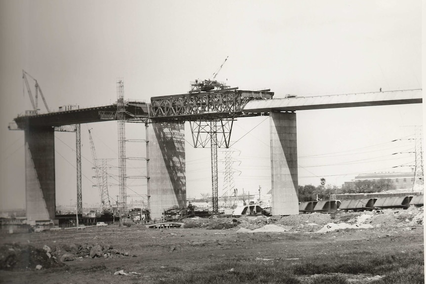 A black and white photo of the West Gate bridge under construction.