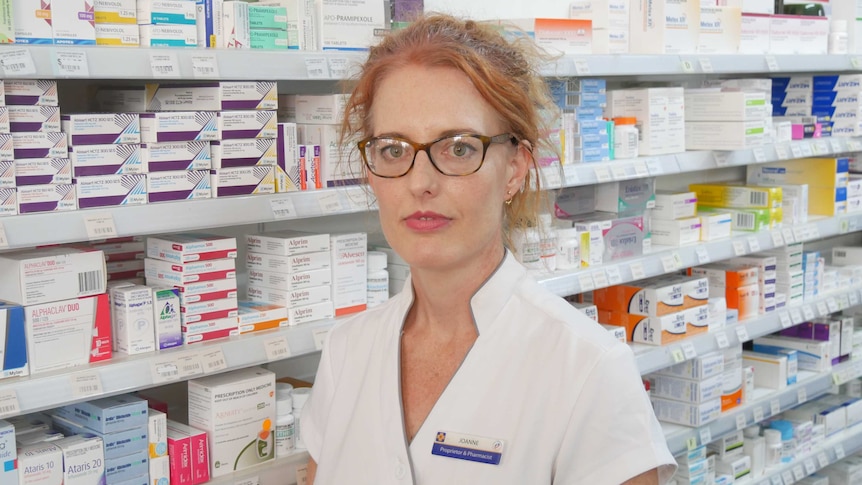 Close up photo of pharmacist Joanne Loftus standing in pharmacy with medications and products behind her