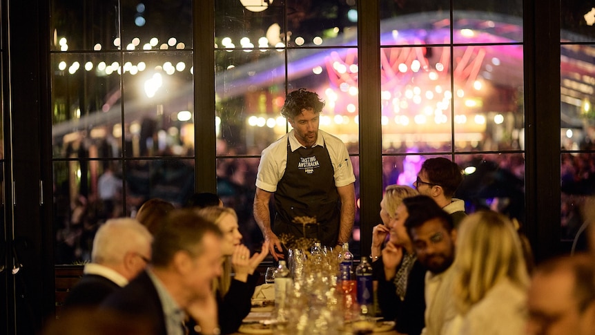 Chef talking to a group of people at a restaurant
