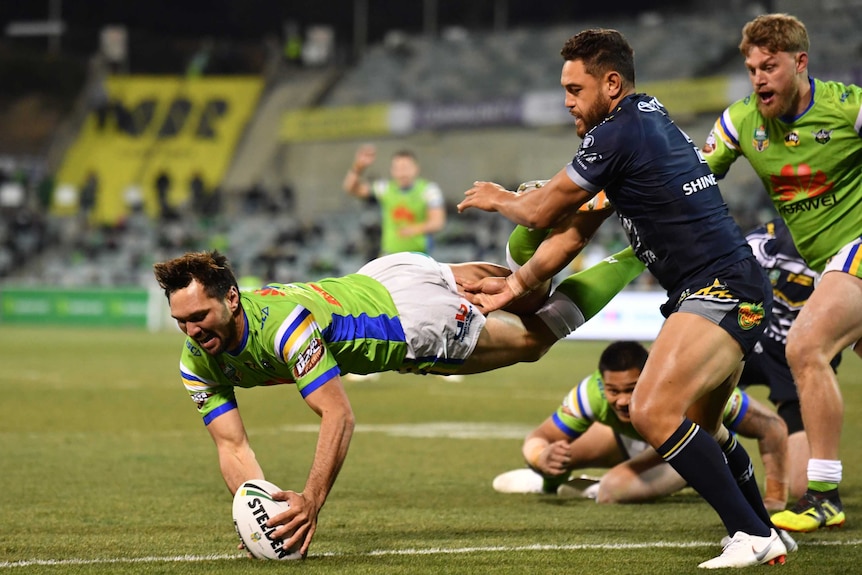 Jordan Rapana grounds the ball as he fives in the air in the Raiders versus Cowboys match.