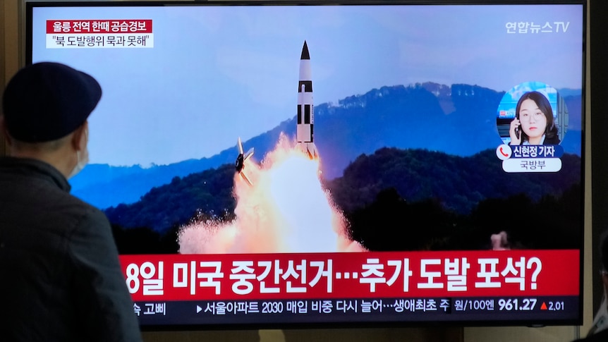 A TV screen shows a file image of North Korea's missile launch.