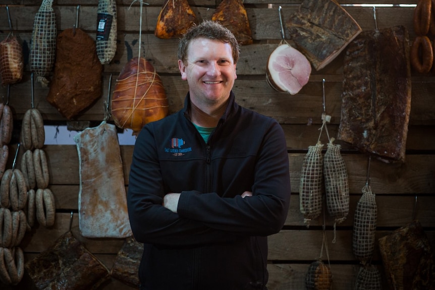 A man standing in a butcher