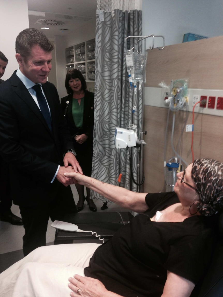 NSW Premier Mike Baird shakes the hand of a cancer patient in a treatment centre.