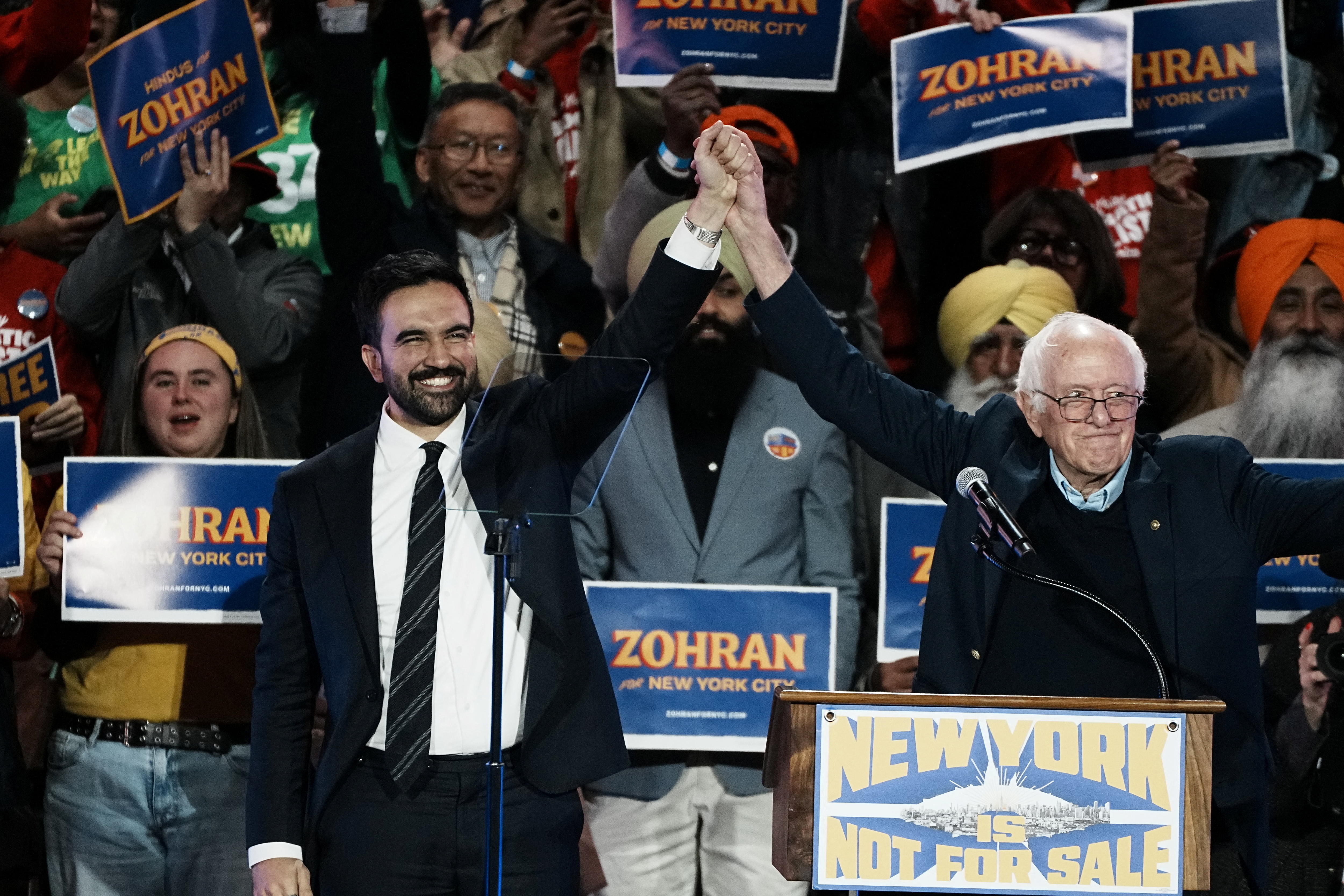 Sanders lifts Mamdani's hand into the air at a rally