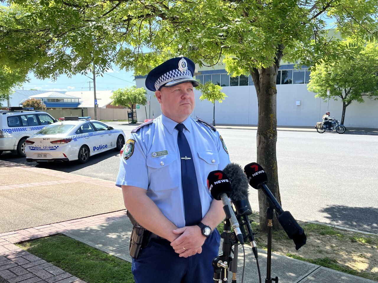 A police officer standing in front of microphones