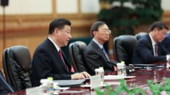 A close up photo of Xi Jinping speaking around a table at the forum.