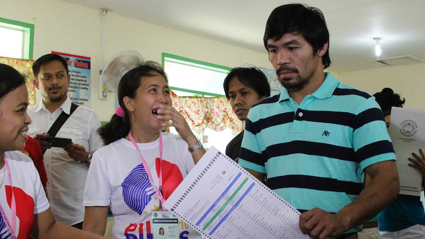 Woman laughs as Manny Pacquiao casts vote in polling booth