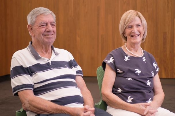 John and Bridget Noble smile as they sit in chairs.